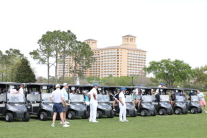 a row of golf carts with men in front of them outside