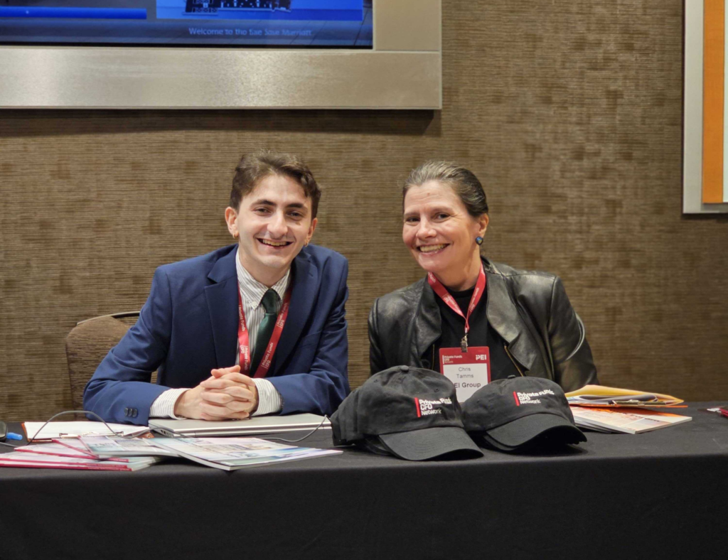 man and women in professional attire sitting at a table with merchandise