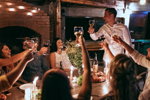 group cheers over long table with candles